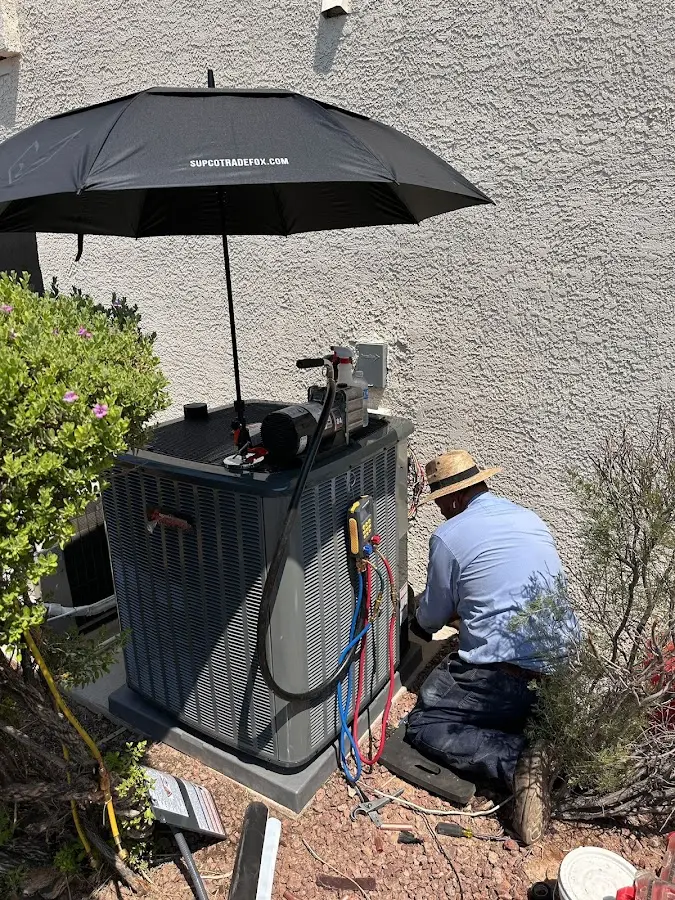 HVAC technician performing outdoor AC maintenance in Petoskey