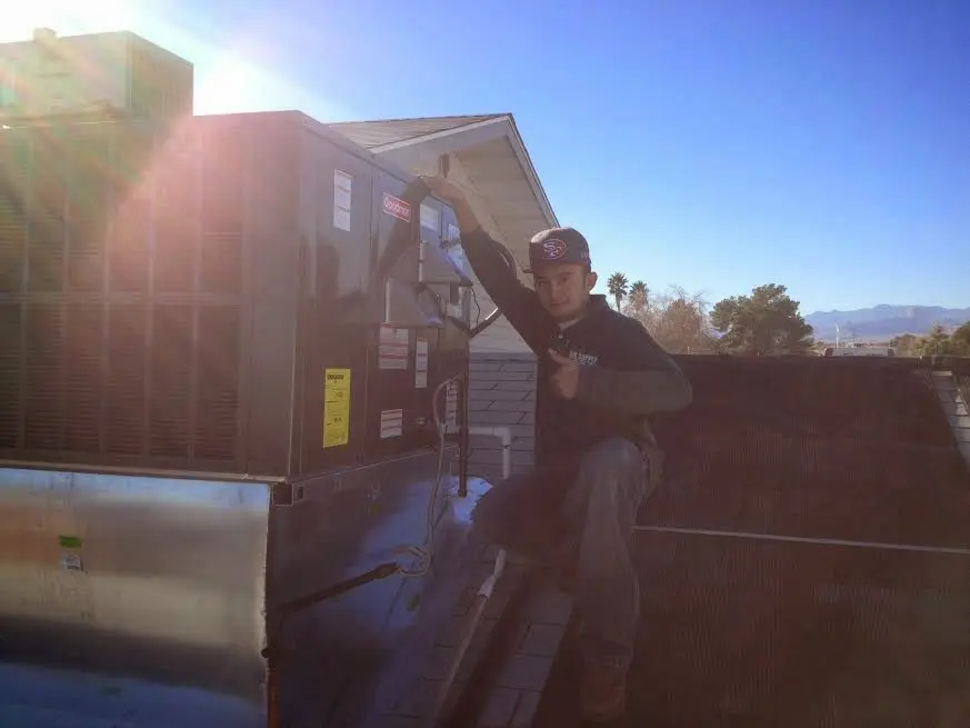 HVAC technician performing HVAC Inspection on a rooftop unit in Petoskey